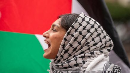 متظاهرة تردد شعارات داعمة الفلسطينيين في غزة، خارج جامعة كولومبيا في مدينة نيويورك، 24 نيسان/أبريل 2024. (رويترز)
