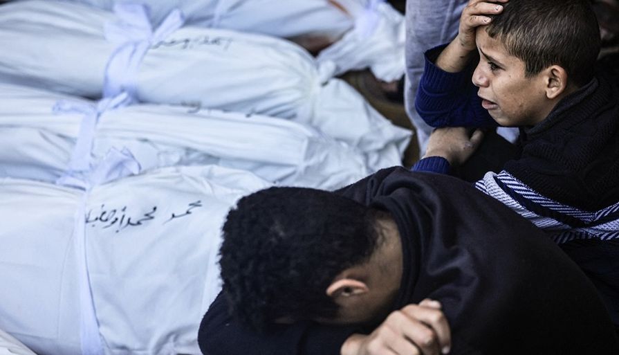 طفل يبكي أمام جثامين شهداء في غزة
