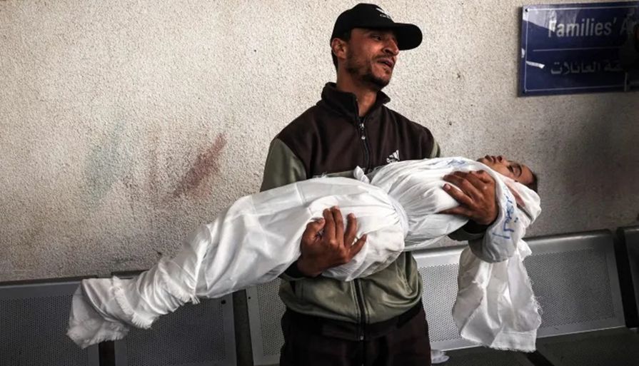 فلسطيني يحمل جثمان شهيد في غزة