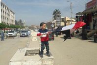 طفل مصرى يرفع العلم المصرى امام احد اللجان بالمنيا