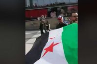 رفع علم الثورة في مسيرة لبشار
