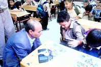 مدير إدارة تعليمية يربط حذاء أحد  تلاميذ الصف الأول الابتدائى