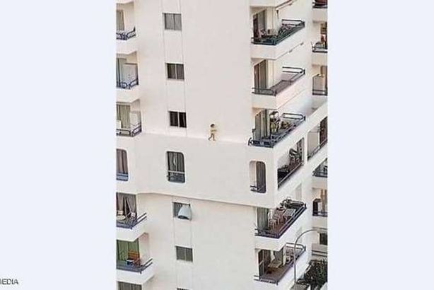 لطفلة تمشي على حافة عمارة