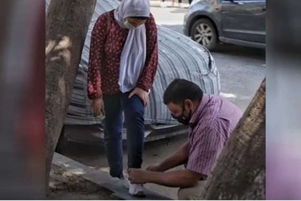 أب يربط حذاء ابنته