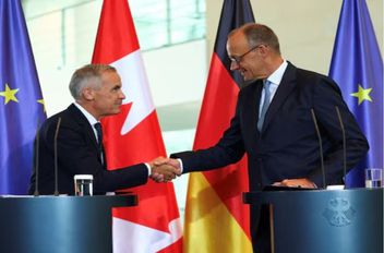 رئيس الوزراء الكندي مارك كارني يصافح المستشار الألماني فريدريش ميرتس خلال مؤتمر صحفي في برلين