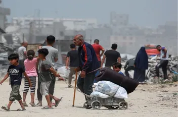 فلسطينيون وسط الدمار الذي خلفه الاحتلال الإسرائيلي