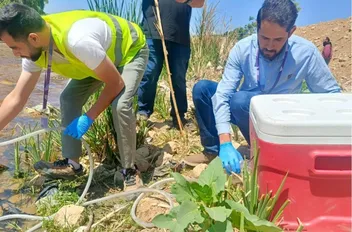 مختصون أخذون عينات من مياه سيل الزرقاء.