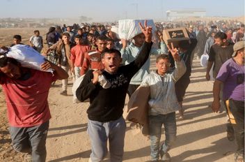 فلسطينيون يحملون إمدادات مساعدات من مؤسسة غزة الإنسانية المدعومة من الولايات المتحدة