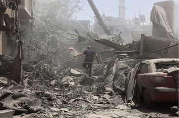 فلسطيني يتفقد الأنقاض بعد غارات إسرائيلية على منزل في حي التفاح بمدينة غزة
