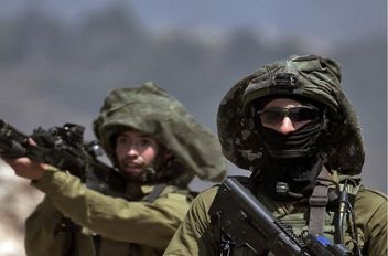 جندي إسرائيلي يوجه بندقيته خلال اشتباكات مع فلسطينيين