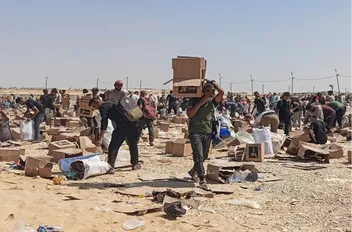 فلسطينيون يجمعون ما تبقى من إمدادات الإغاثة من مركز توزيع المساعدات في غزة