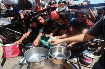 فلسطينيون يتجمعون لتلقي الطعام من مطبخ خيري