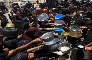 فلسطينيون يتجمعون لتلقي الطعام في مدينة غزة