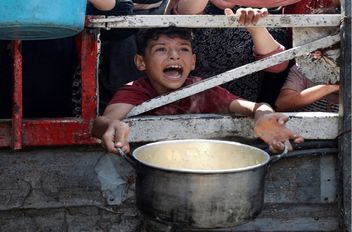 طفل فلسطيني ينتظر الحصول على الطعام