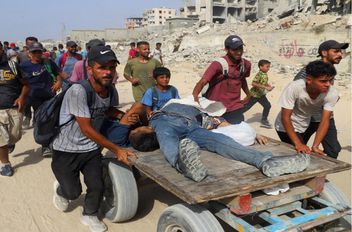فلسطينيون أصيبوا بنيران إسرائيلية يتم نقلهم على عربة في غزة