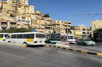 باصات نقل عام عند أحد محطات تحميل الركاب في عمّان.