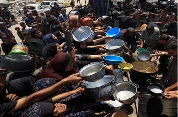 فلسطينيون يتجمعون لتلقي الطعام في مدينة غزة