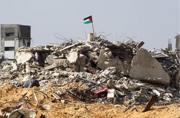 علم فلسطين يرفرف بين أنقاض المباني المدمرة في رفح