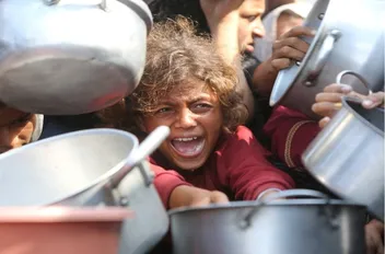 طفل فلسطيني ينتظر الحصول على الطعام من مطبخ خيري في غزة