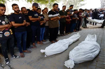 فلسطينيون يصلون الجنازة على جثامين شهداء في مستشفى الشفاء في مدينة غزة