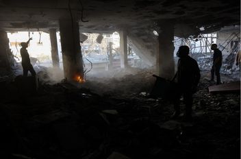 فلسطينيون يبحثون عن ناجين في موقع غارة إسرائيلية استهدفت مباني