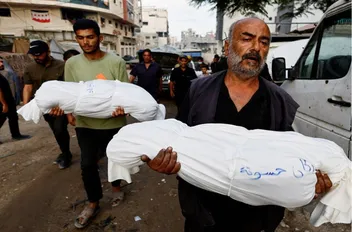 فلسطيني يحمل جثمان طفل في غزة